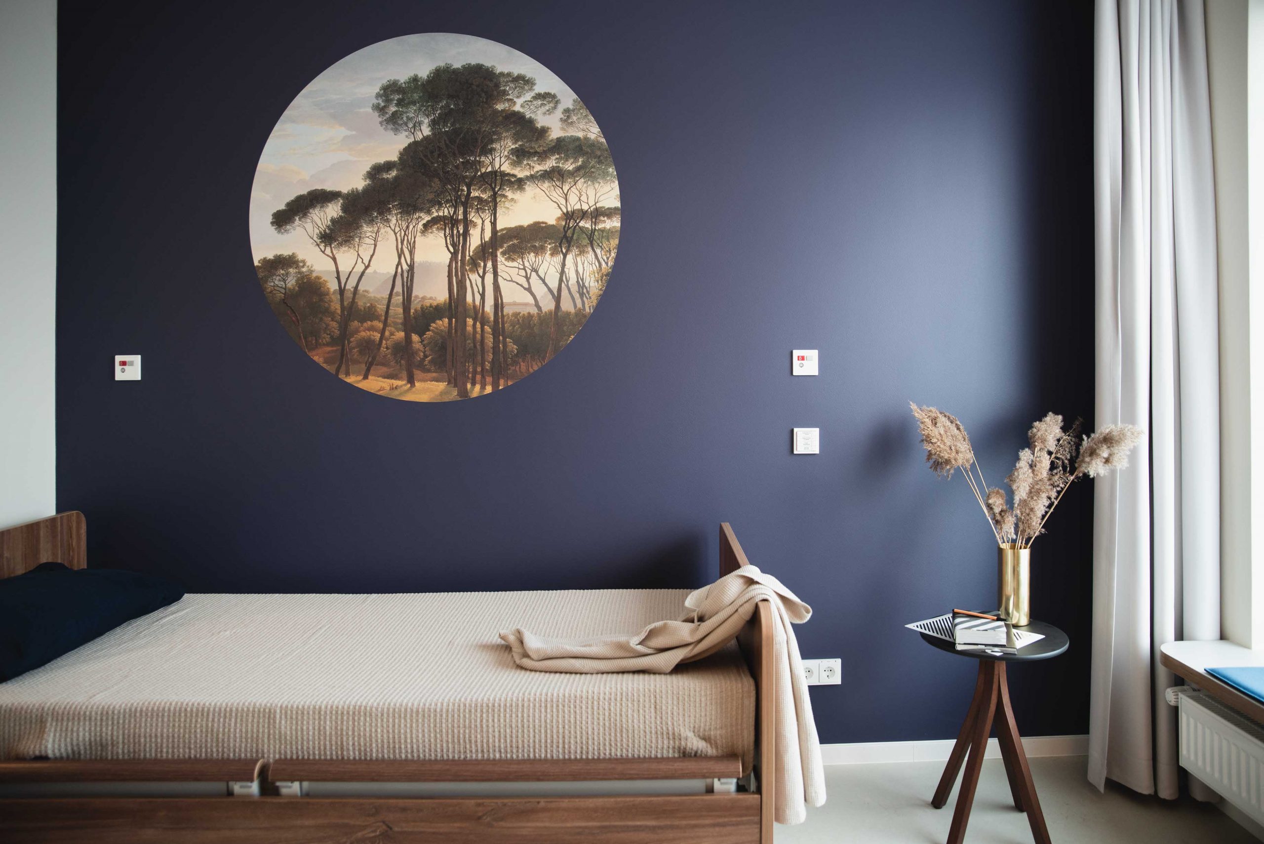 Zimmer Pflegeheim blaue Wand mit runder Tapete über dem Bett 