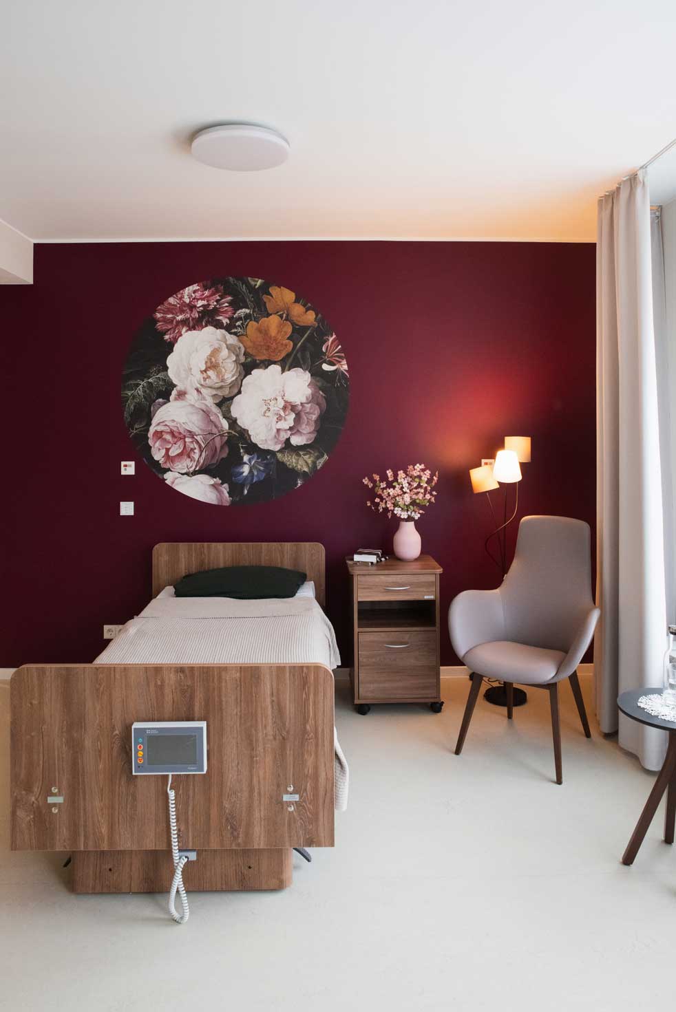 Wilkening_Zimmer_Blumen Doppelzimmer rote Wand mit oppulenter Blumentapete und gemütlicher Leseecke