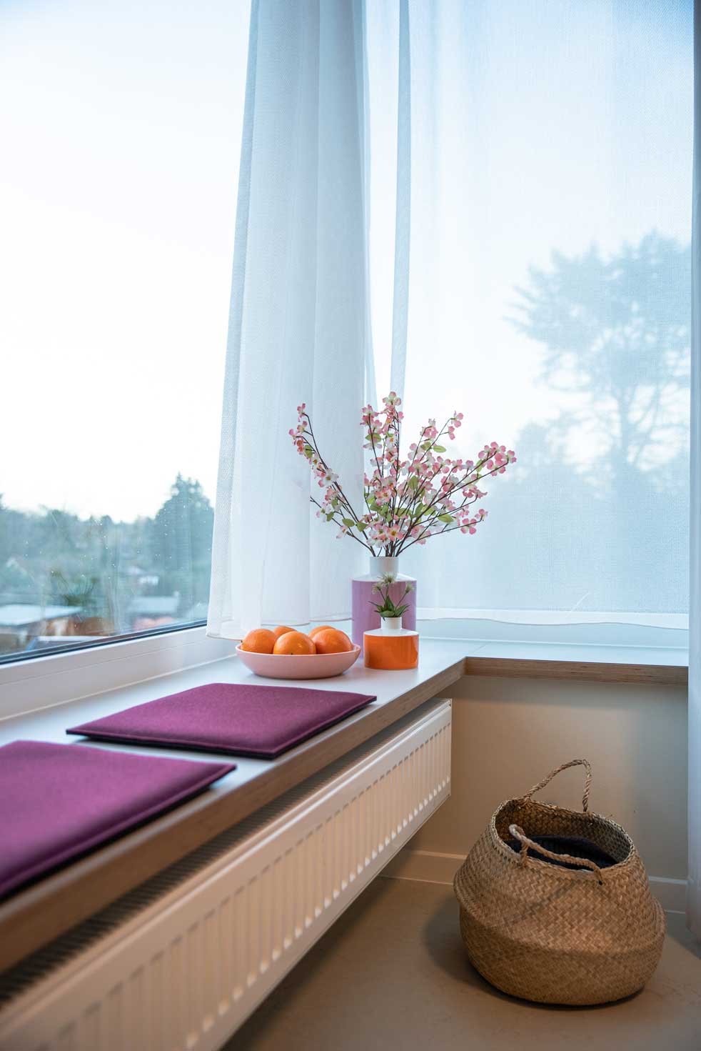 Wilkening_Zimmer_Eckzimmer_Sitzkissen_rot Bewohnerzimmer breite Fensterbank mit Sitzkissen aus Filz
